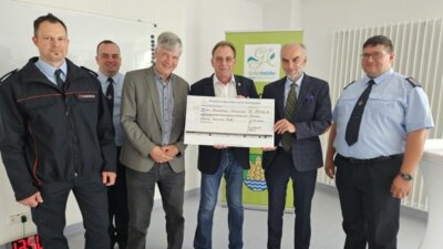 Scheckübergabe: Staatssekretär Markus Grünewald (2. von rechts) hat Bürgermeister Arne Christiani (3. von rechts) die Fördermittelzusage über 827.000 Euro übergeben - und das im Beisein von Mönchwinkels Ortswehrführer Steffen Broz (links) , dessen Stellvertreter Falko Brunn (rechts), Gemeindewehrführer Tobias Thieme (2. v.l.) sowie Michael Buhrke, Finanzdezernent im Landkreis Oder-Spree. Foto: Anke Beißer (Bild vergrößern)