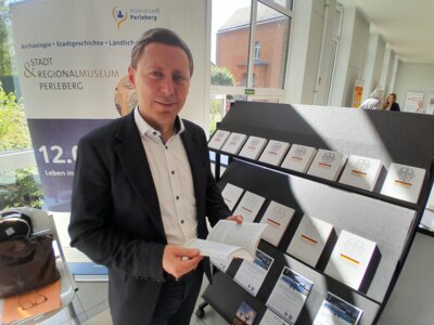 Foto: Rolandstadt Perleberg | Bürgermeister Axel Schmidt blättert in der Ausstellung im Grundgesetz.