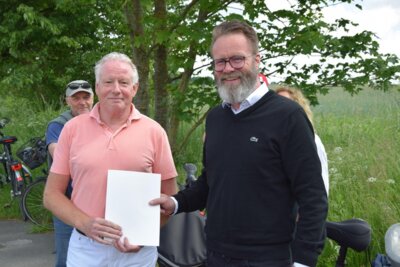 Minister Madsen übergibt Bürgermeister Krumbügel den Förderbescheid. Foto: Reinhard Friedrichsen.