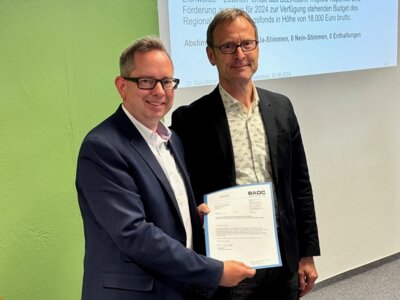 Oliver Igel, Bezirksbürgermeister von Treptow-Köpenick, nimmt die Förder-Urkunde für das Projekt 