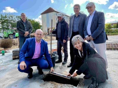 Die Zeitkapsel wird von Landrat Christian Müller und Ellen Winterfeld, Schulleiterin der Albert-Schweitzer-Schule, eingelassen I Foto: Gina Werthe/Landkreis Prignitz (Bild vergrößern)