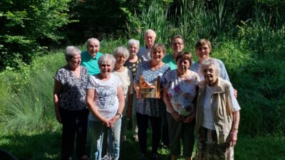 Gruppenfoto mit den neun Teilnehmerinnen und zwei Teilnehmerinnen am Besuch der ILCO Regionalgruppe im Hospiz am Drachenkopf. Sie stehen in zwei lockeren Reihen bei Sonnenschein auf einer kleinen Wiese. (Bild vergrößern)