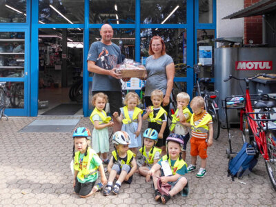 Die Kitakinder freuen sich über die Helme, die Fahrradhändler Lutz Spieker der Kita Kinderland gespendet hat. Foto: Kita Kinderland (Bild vergrößern)