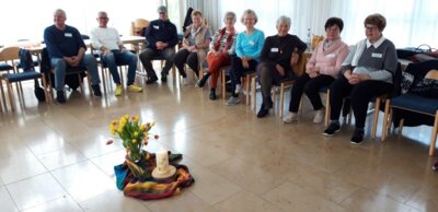 Menschen, Stuhlkreis, Kerze, Blumen (Bild vergrößern)