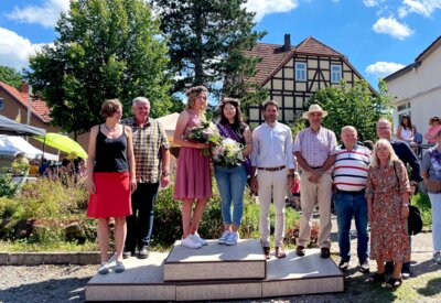 Krönung Lina I. übergibt das Zepter: Während des 19. Heideblütenfest in Altenlotheim krönten Kristin Gampfer (links), Geschäftsführerin des Naturparks Kellerwald-Edersee und Nationalparkleiter Manuel Schweiger (5.v.l.) Saija I. (4.v.l.) zur neuen Heideblütenprinzessin. Lina I. (3.v.l.) beendete damit ihre 2-jährige Amtszeit. Bildautor: Nationalpark Kellerwald-Edersee (Bild vergrößern)