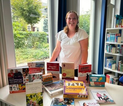 Bibliotheksleiterin Carolin Renkewitz mit einer Auswahl von Medien für Menschen mit und ohne Demenz  I Foto: Stadtbibliothek Wittenberge (Bild vergrößern)