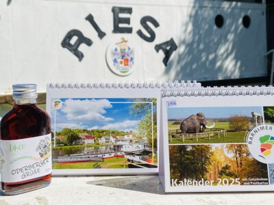 Der Kalender vom Barnimer Land für 2025 beim Fotoshooting im Museumspark vor dem Seitenraddampfer RIESA