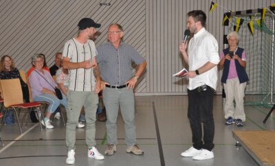 Sportstudio-Moderator Fabian Buck (mit Mikrofon) begrüßt Thomas Hennch (links) und Kurt Böhm zum obligatorsichen Torwandschießen. Im Hintergrund rechts Renate Bernreuther, die seit 1987 die Kinder- und Jugendmannschaften der Fußballabteilung betreut.