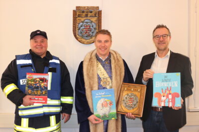 (von links) Stadtbrandinspektor André Bernhardt, Bürgermeister Thomas Eckhardt und Hänselmeister Daniel Kohl werden in den Sontraer Kindertagesstätten aus ihren spannenden Büchern vorlesen (Bild vergr&ouml;&szlig;ern)