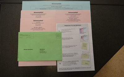 3.3.1./ 3.3.2/ 3.3.4. Unterlagen für die Gemeindevertreterwahlen, Bürgermeisterwahl und Ortsvorsteherwahl: grüner Wahlschein, blauer und rosa Stimmzettel, grauer Stimmzettelumschlag und grüner Wahlbrief
