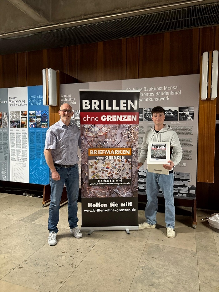 2025-04-16_BRILLEN-ohne-GRENZEN_Patrick-Adams-UNI-SB-MENSA___David_Martin_Brillen-Uebergabe_V-700