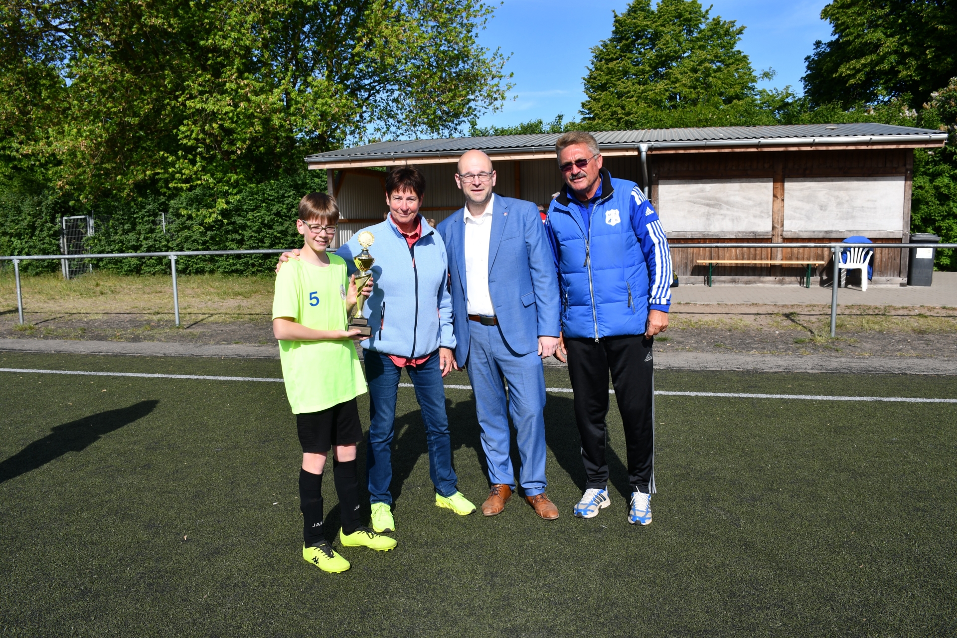 Schüler Nino Frauendienst (Klasse 6b, l.) und Lehrerin Birgit Kreklow erhielten aus der Hand von Landrat Christian Müller der Wanderpokal der Grundschulen, zur Freude von Organisator Frank Dannehl (r.). Foto: Bernd Atzenroth/Landkreis Prignitz
