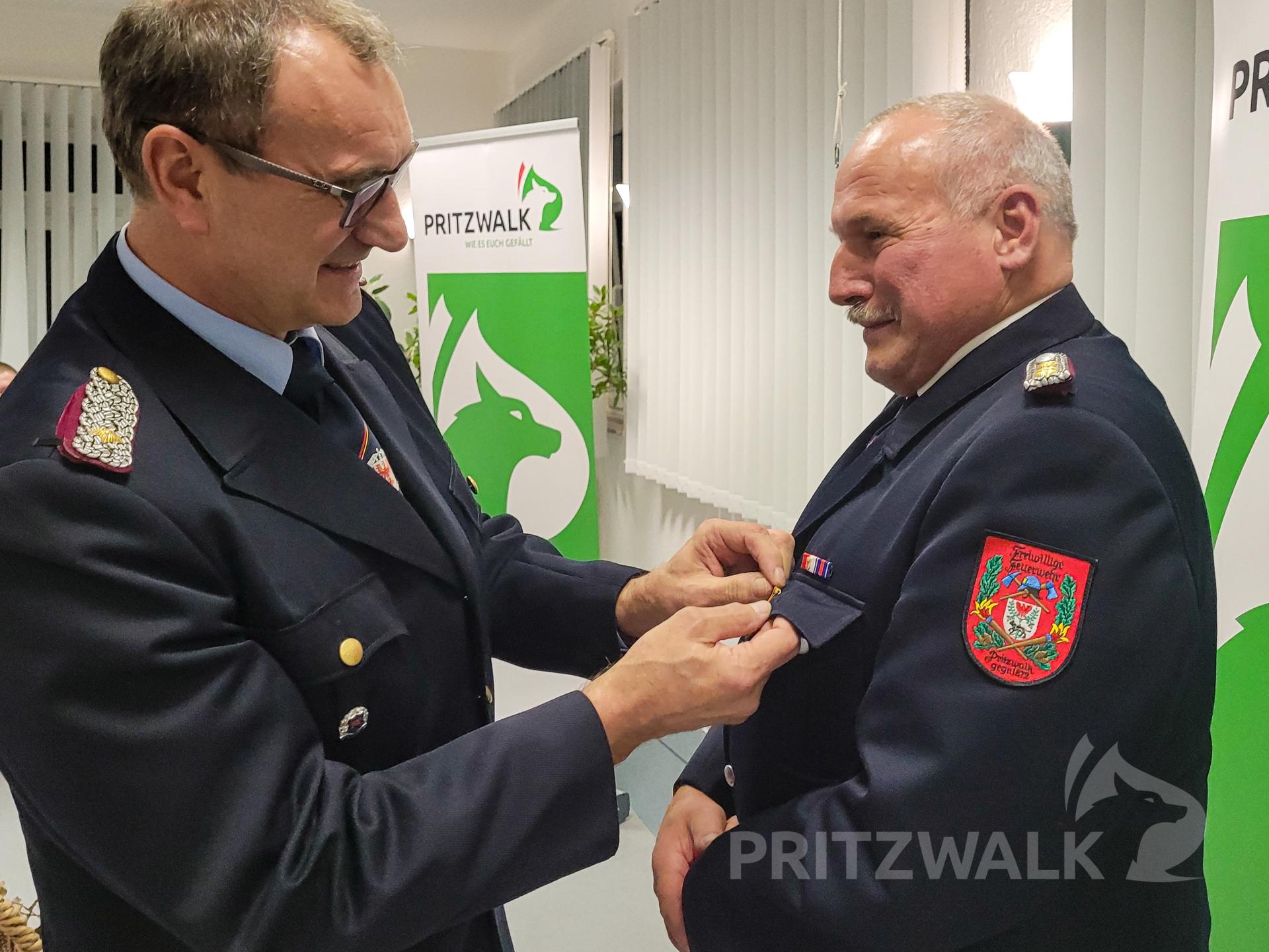 Kreisbrandmeister Holger Rohde heftet einem sichtlich überraschten Klaus Köpke den Orden des Deutschen Feuerwehrverbandes in Bronze an. Foto: Beate Vogel