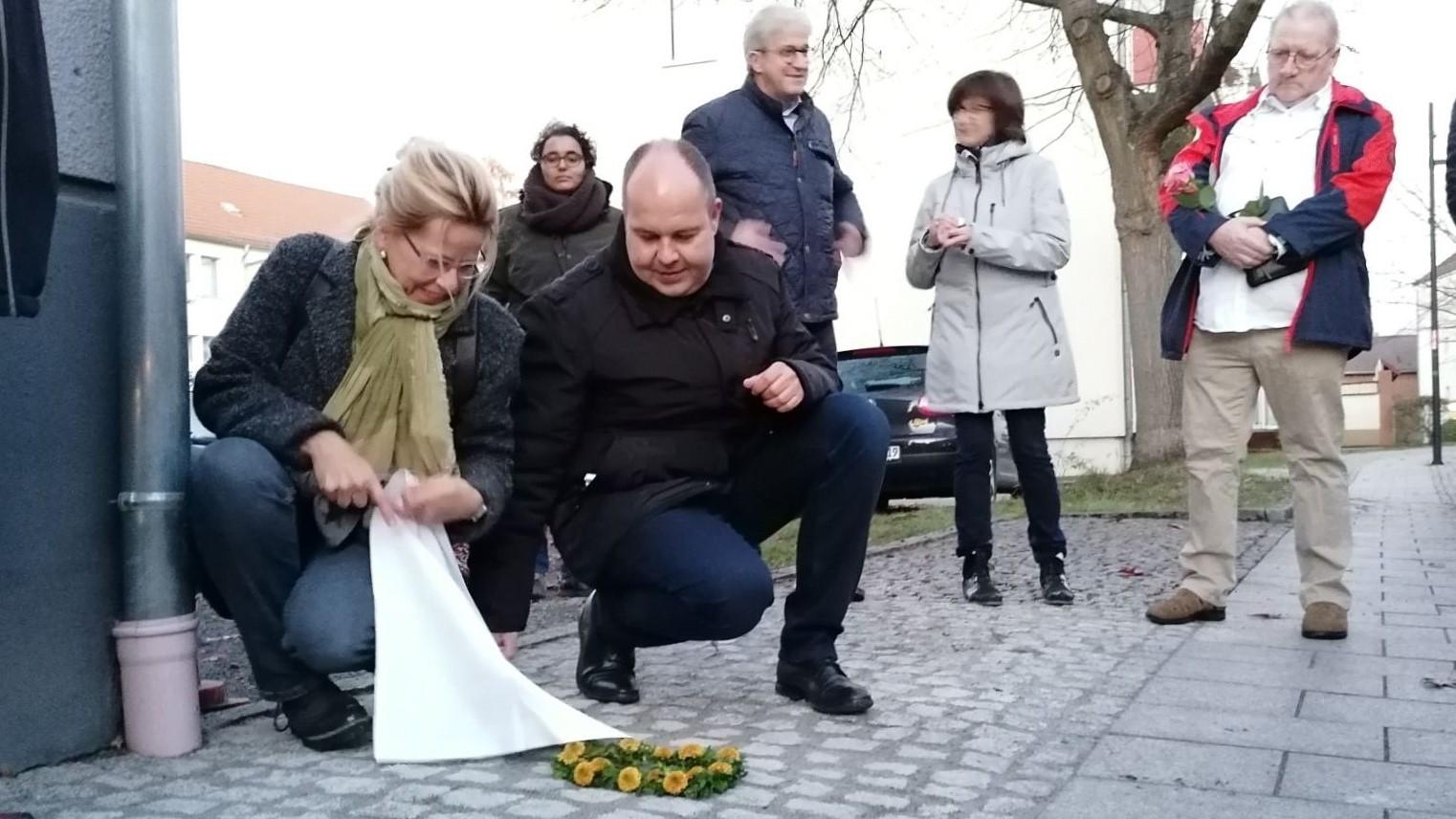 Patin Antje Jahn und Lübbens Bürgermeister Lars Kolan enthüllen die Stolpersteine im Gedenken an Familie Moses. Foto: Dörthe Ziemer