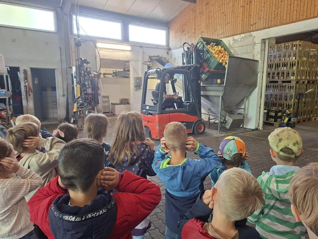 Kinder beobachten interessiert die Saftproduktion