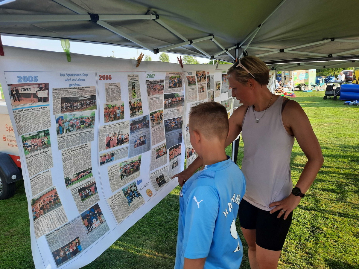 Gesamtsiegerin 2006 und 2007 Britta Eilers, geb. Fischer, zeigte ihrem Sohn an der Stellwand mit ehemaligen Zeitungsartikeln und Bildern ihre sportlichen Erfolge aus den Anfangsjahren der Laufcup-Serie.