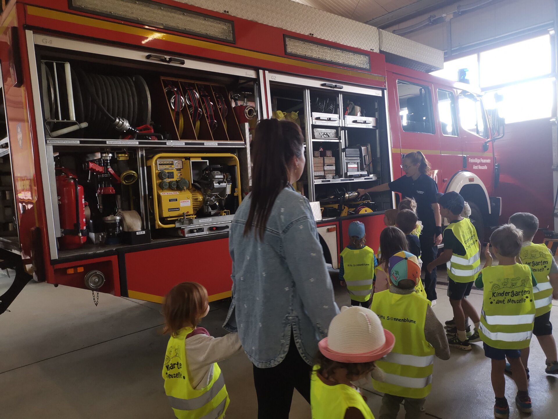 Die Kinder bestaunen ein Feuerwehrauto