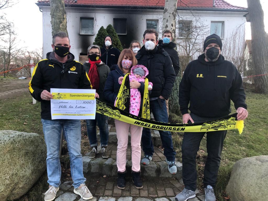 Die betroffenen Familien mit einem Scheck vom BVB-Fanclub Rügen