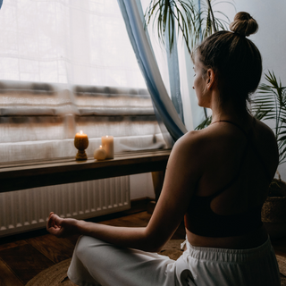 Frau meditiert vor Fenster