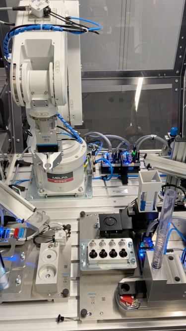Am BKO gehört jetzt ein 6-Achs-Knickarmroboter von Mitsubishi mit entsprechender Peripherie zur Ausstattung des Werkstattgebäudes. Nahaufnahme der Roboterstation