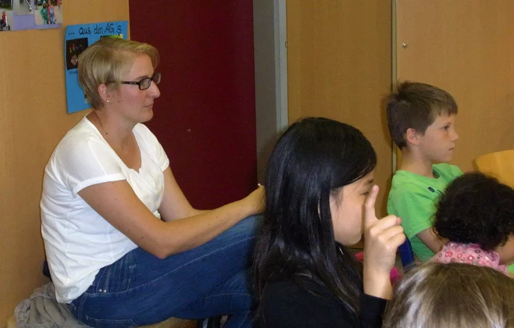 Eine Lehrerin beobachtet und Berät in der Debatte von hinten