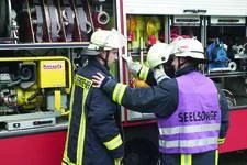 3 Feuerwehrmänner bei einer Einsatzvorbereitung