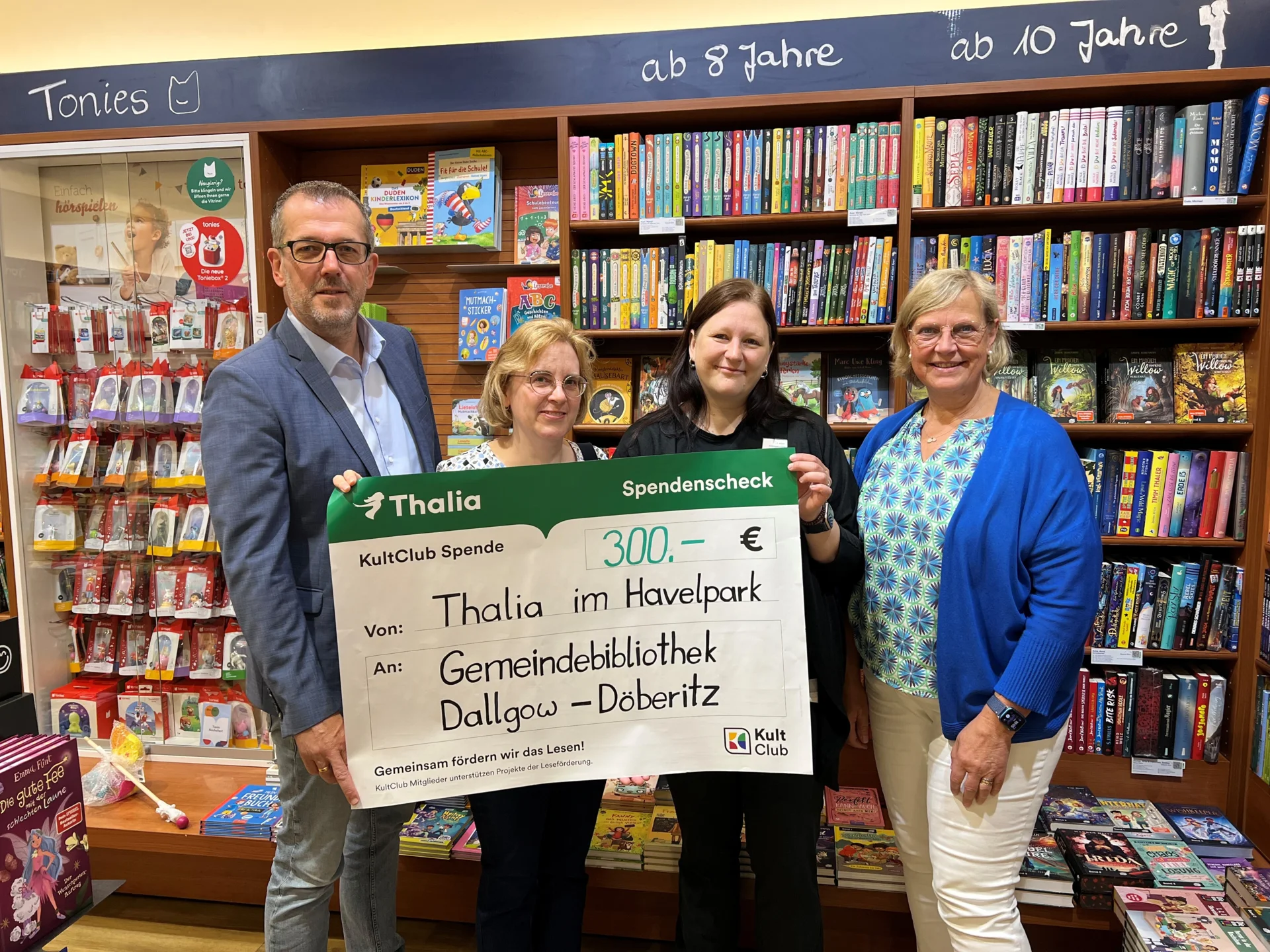 Scheckübergabe von Katrin Köber (Filialleitung) an Bürgermeister Sven Richter, Nora Weisse (Bibliotheksangestellte) und Claudia Neubauer (Ehrenamtlerin)