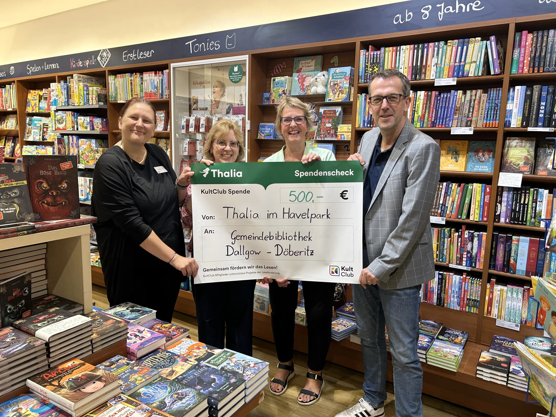Spendenübergabe von Filialleiterin Katrin Köber an Bürgermeister Sven Richter, Bibliotheksangestellte Nora Weisse und ehrenamtliche Mitarbeiterin Isabella Rosen-Hoffmeister