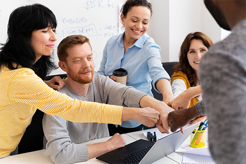 froehliche-menschen-beim-fistbump-im-workshop