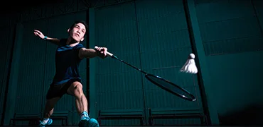 professionelle-badmintonspieler-verwenden-schlagerschlager-oder-federball-auf-dem-platz-wahrend-des-aufwarmspiels-vor-dem-turnierwettbewerb-im-einzelmanntyp-der-halle