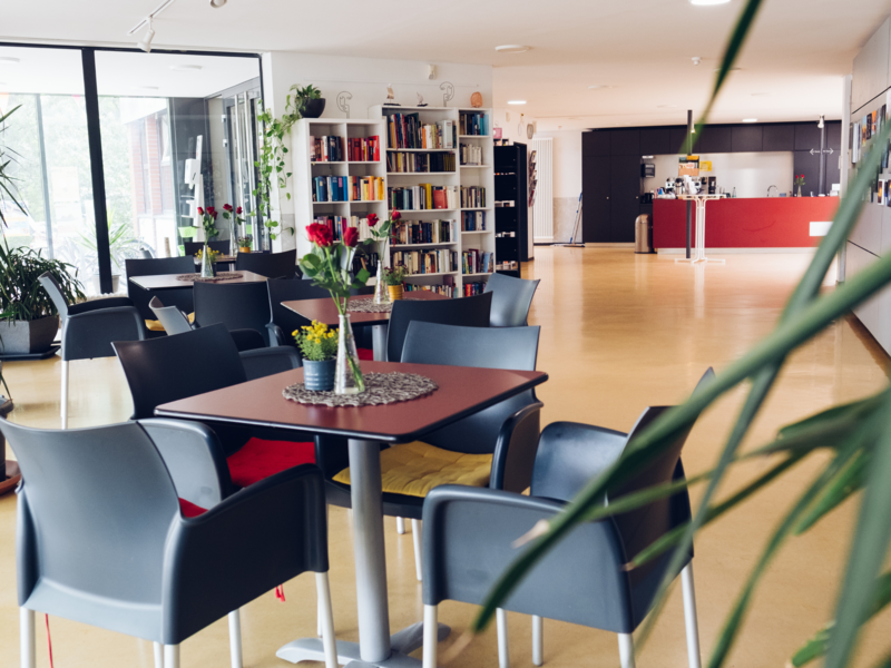 Foyer- Blick über die Tische in den Raum, im Hintergrund die Theke