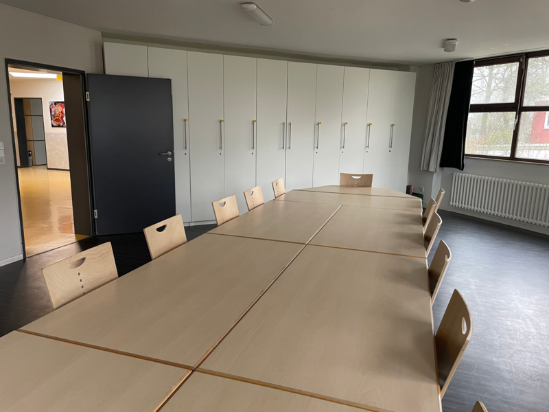 Gruppenraum_1 Blick über großen Konferenztisch im Hintergrund die Fenster