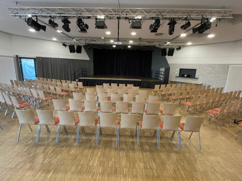 Saal-Blick über die Bestuhlung auf die Bühne
