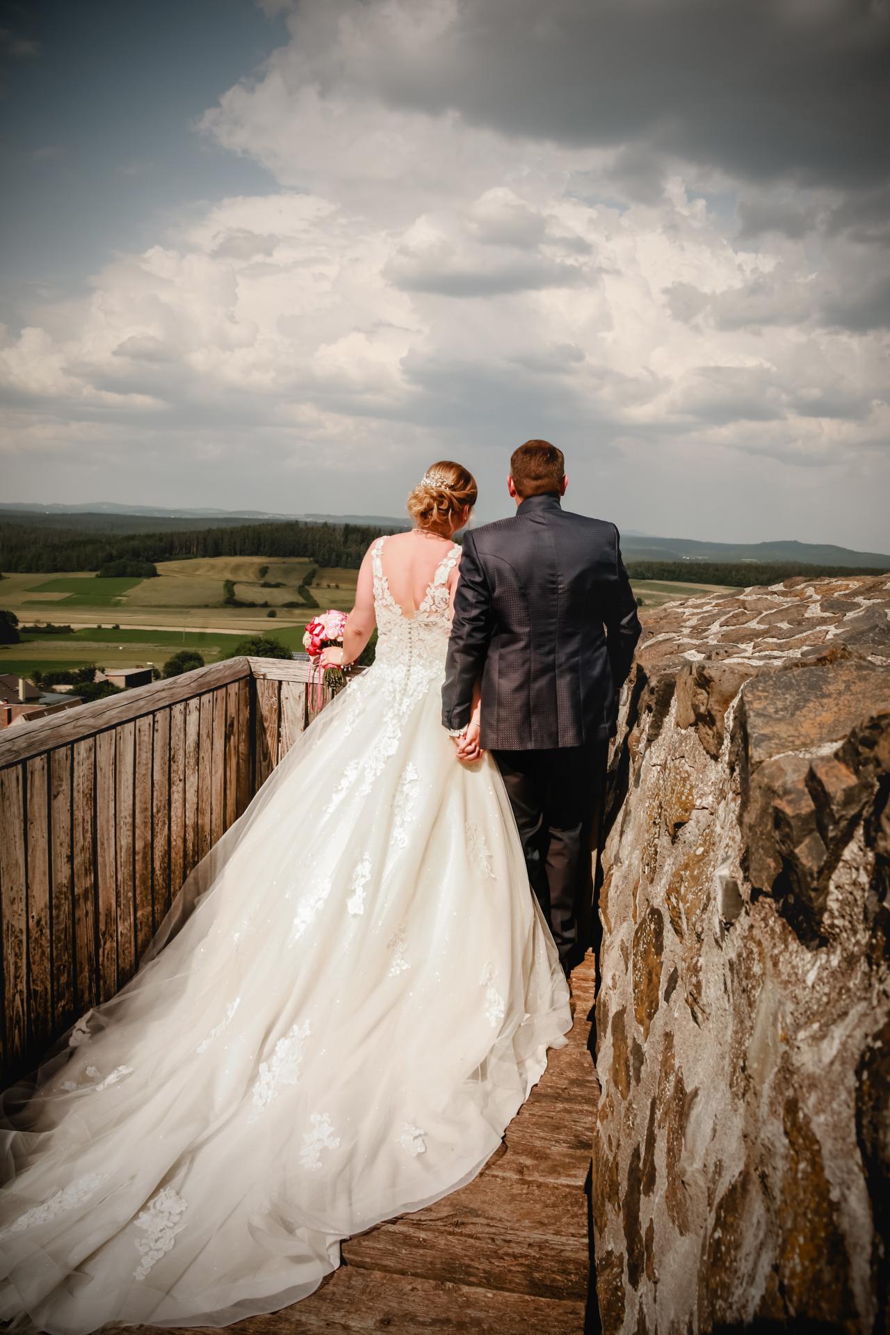 Brautpaar blickt über die Mauern in Richtung Pfannenstiel