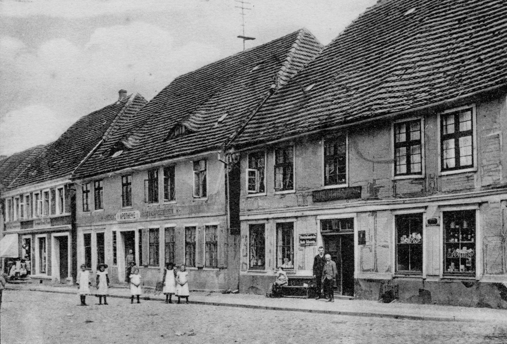 Apotheke und Geschäft Bruger (rechts) auf einer Ansichtskarte von 1901 oder früher.