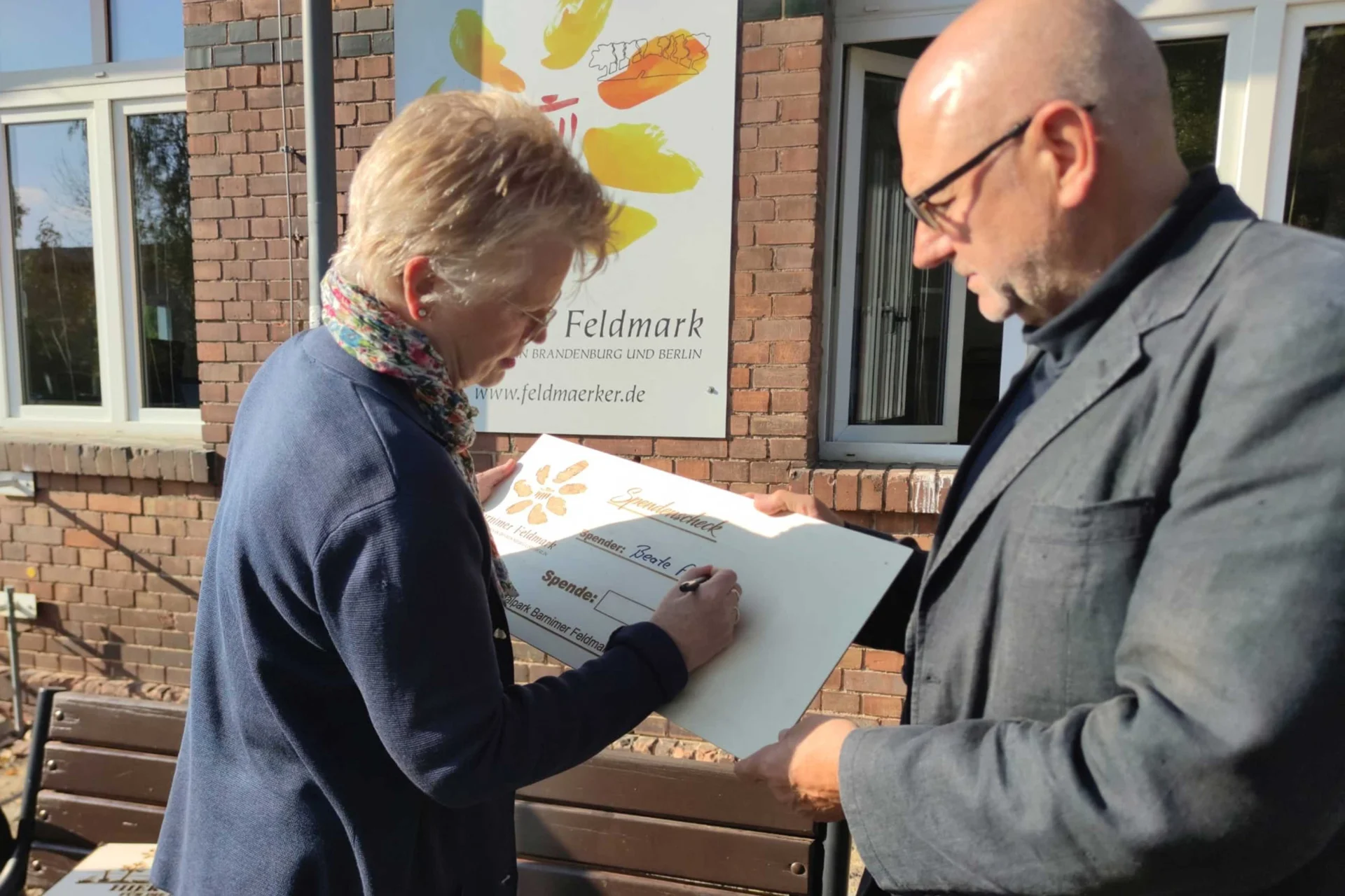 02_Baumspende_Beate_Profé_unterschreibt_Spendenscheck