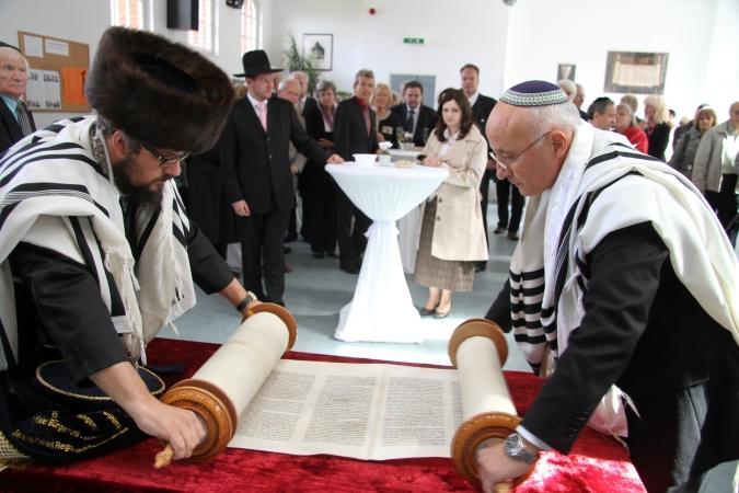 Новую Тору разворачивают в зале синагоги