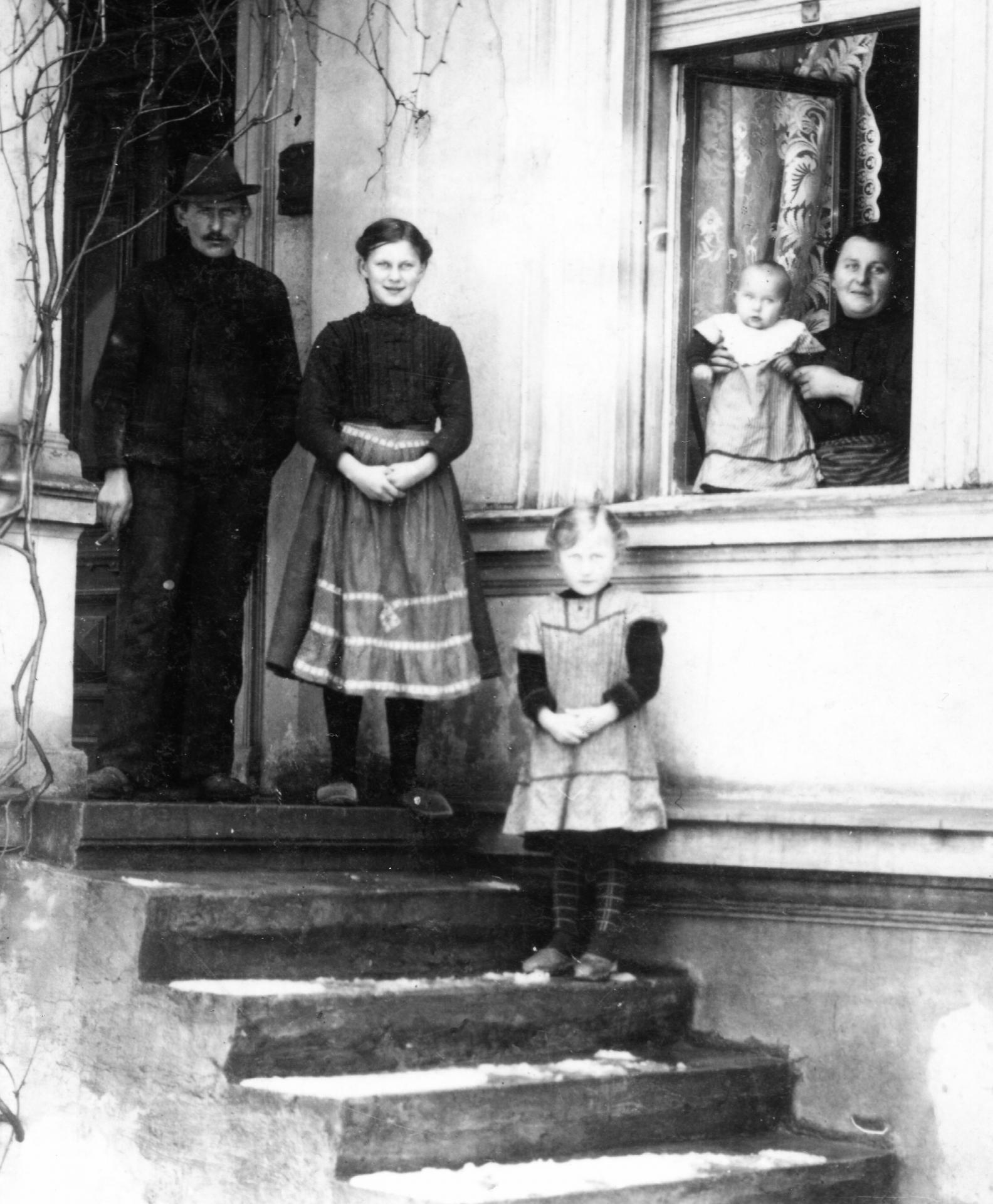 Familie Henkel auf der Treppe des Hauses mit Dienstmädchen