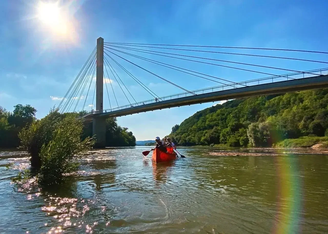 Personen auf dem Wasser vor der Brücke