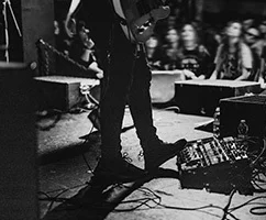 musiker-mit-einem-pedalboard-einem-konzert