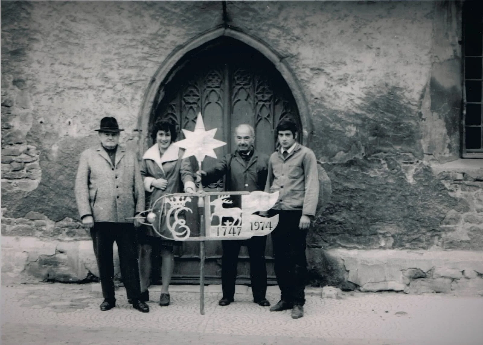 Wetterfahne mit Gustav Hänsch, Pastorin Monika Beate, Uhrmachermeister Ernst Lies sen. und unbekannter Person, 1974