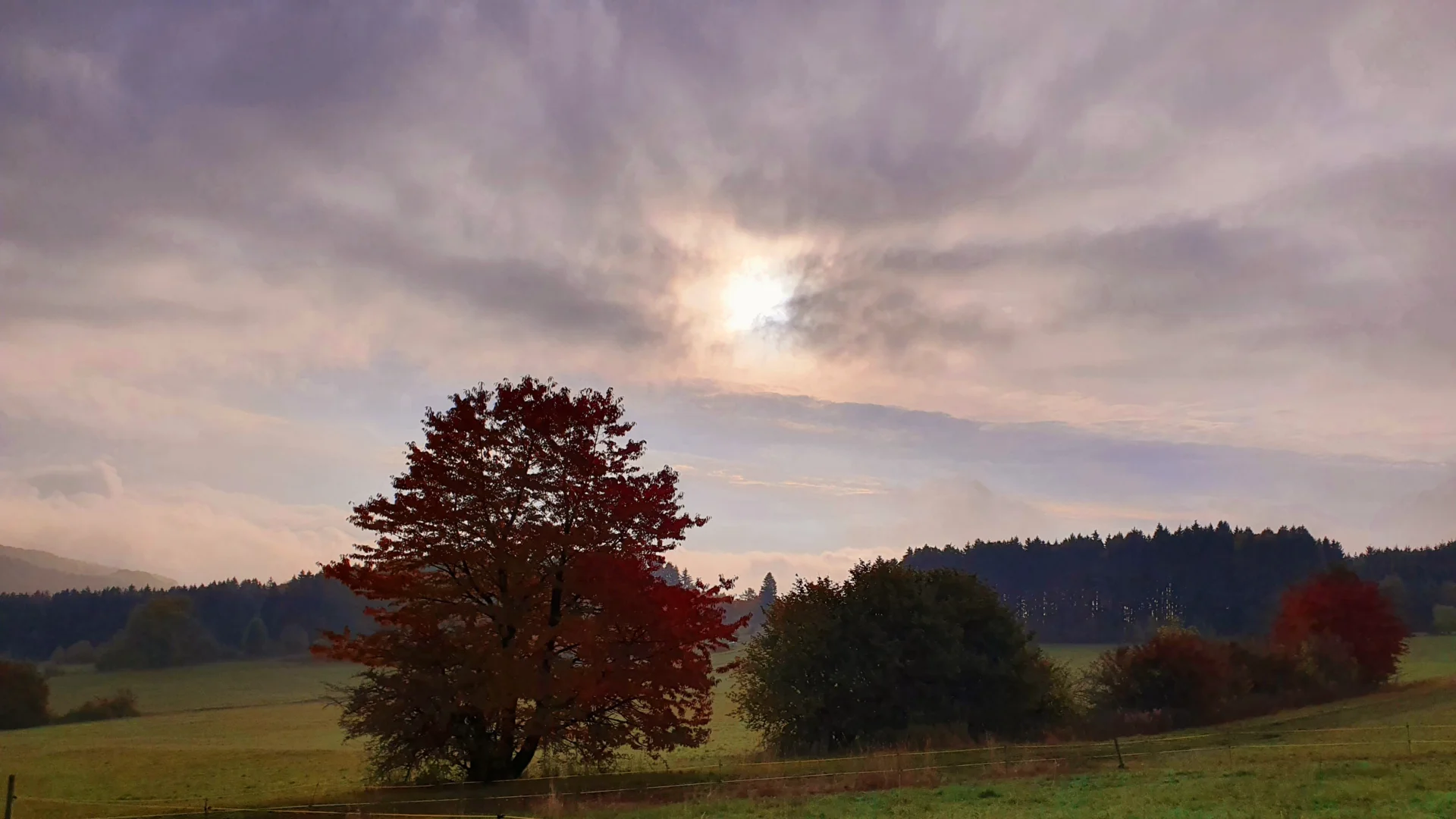 Landschaftt mit der Sonne sichtbar zwischen den Wolken