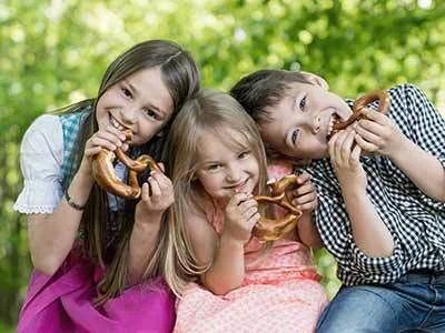 3 Kinder essen jeweils eine Bretzel