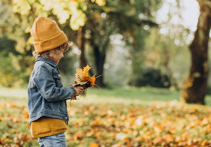kind-im-herbst-mit-blaettern