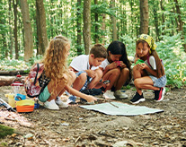 kinder-schauen-auf-karte-im-wald