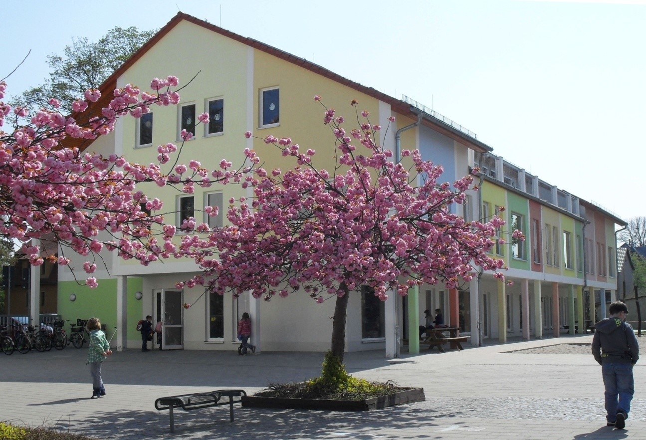 Hortgebäude im Frühling umgeben von rosa Kirschbäumen