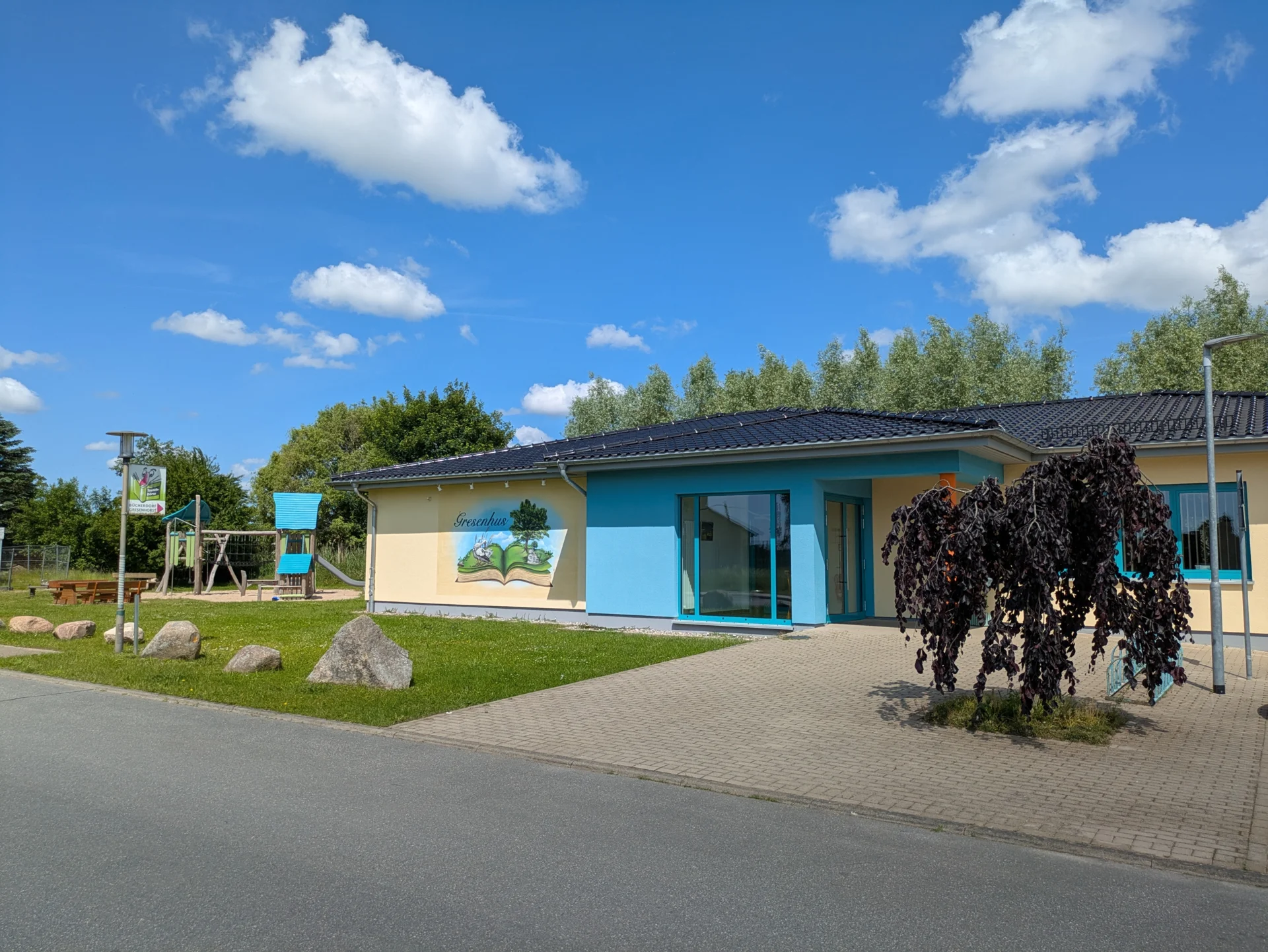 Außenansicht Gresenhus mit Parkplätzen und Spielplatz