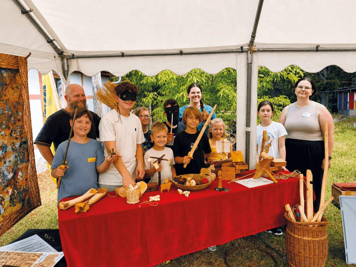 Impression aus der Sommerfreizeit 2026 "Abenteuer Mittelalter": Gruppenfoto hinter dem Thementisch zu Spielzeug aus dem Mittelalter