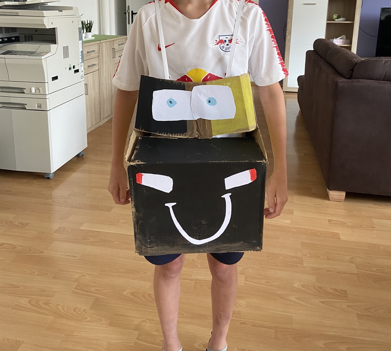 Kind mit selbstgebasteltem Auto zum Umhängen