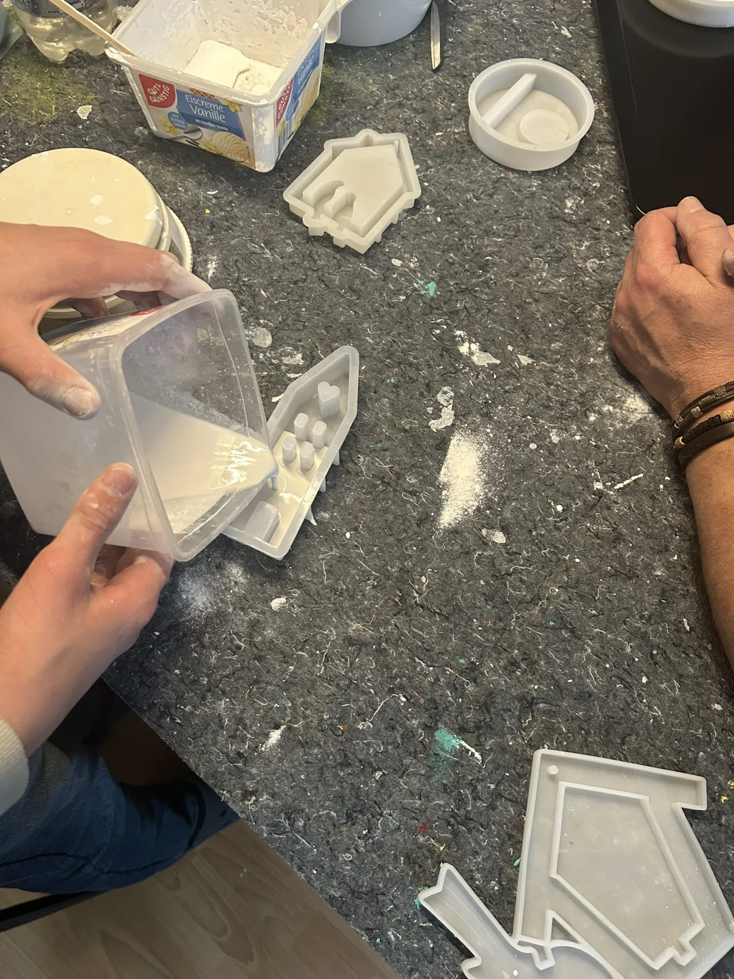 Kind gießt Gips in ein Förmchen